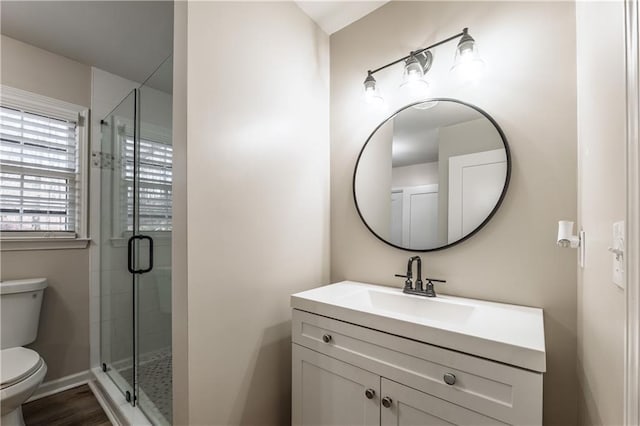 full bathroom featuring a stall shower, toilet, and vanity