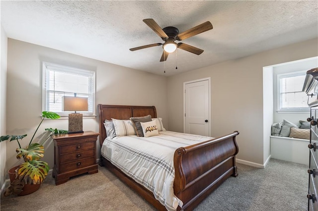 bedroom featuring a ceiling fan, baseboards, carpet floors, and a textured ceiling