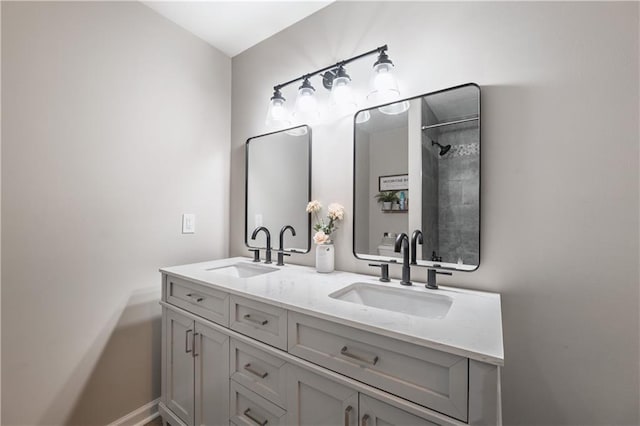 bathroom with double vanity, baseboards, and a sink