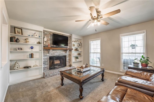 carpeted living room featuring built in features, baseboards, a ceiling fan, and a fireplace