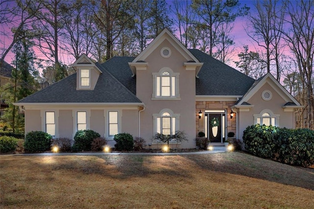 view of front of property with stone siding, a shingled roof, and stucco siding