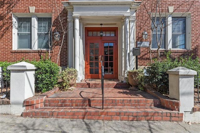 property entrance featuring brick siding and french doors