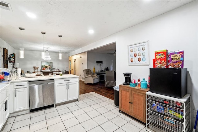 kitchen with white cabinets, ceiling fan, stainless steel dishwasher, light wood-type flooring, and decorative light fixtures