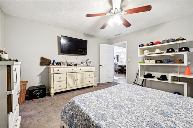 carpeted bedroom with ceiling fan and a textured ceiling