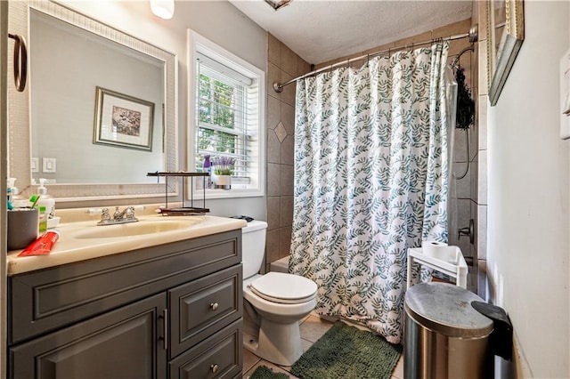 bathroom with a textured ceiling, toilet, vanity, curtained shower, and tile patterned flooring