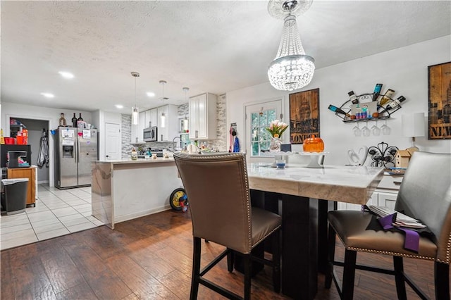 dining space featuring a notable chandelier and light hardwood / wood-style floors