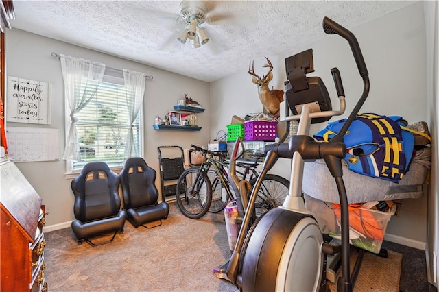 exercise room with a textured ceiling, carpet flooring, and ceiling fan