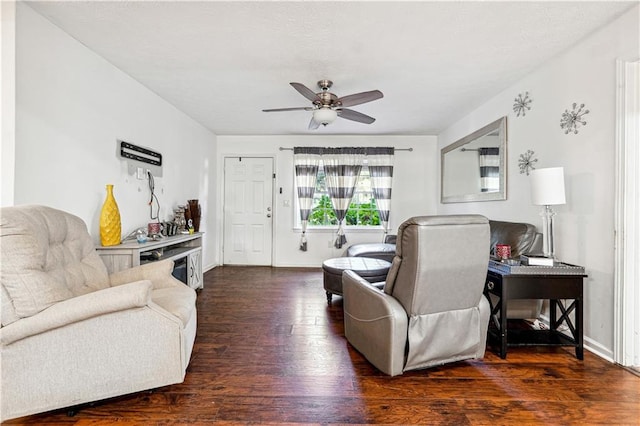 living room featuring dark wood-type flooring and ceiling fan