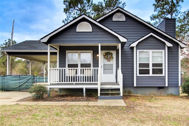 view of front of home with a porch, a chimney, concrete driveway, a front lawn, and crawl space