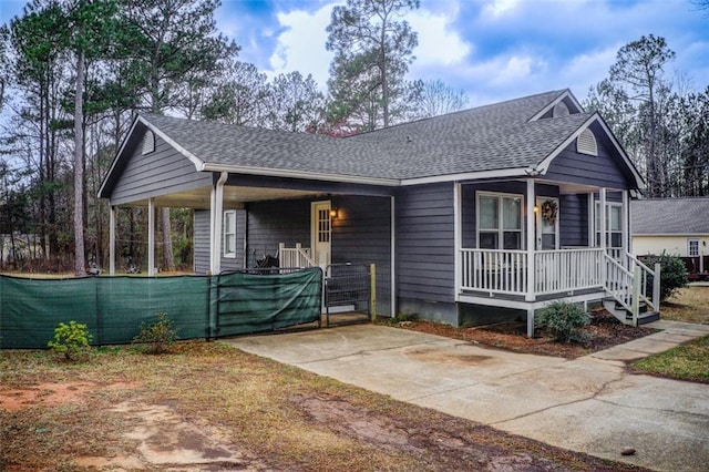 view of front facade featuring covered porch and a shingled roof