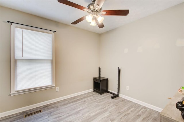 unfurnished room featuring light wood finished floors, visible vents, ceiling fan, and baseboards