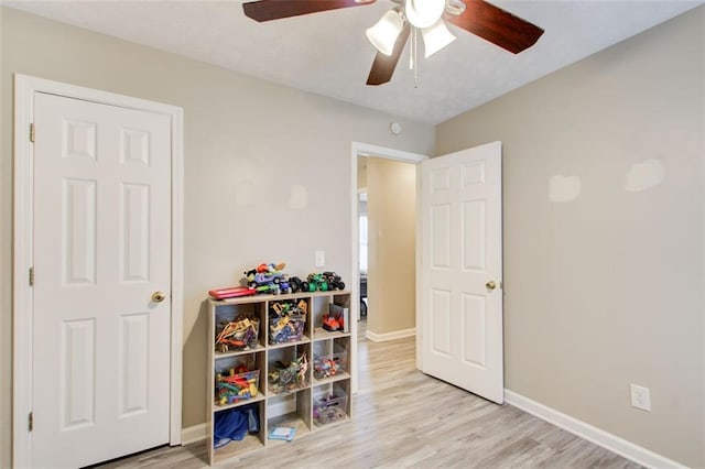 game room featuring a ceiling fan, baseboards, and wood finished floors