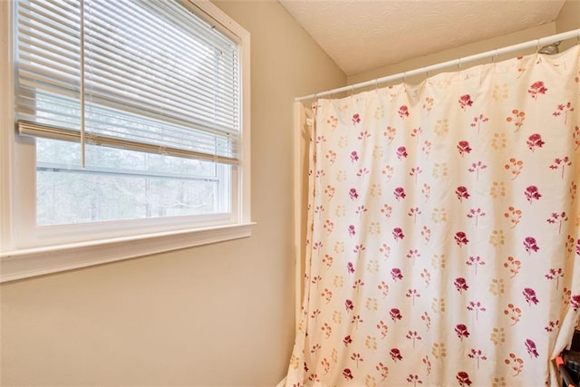 full bathroom with a shower with curtain and a textured ceiling