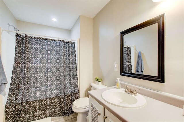 full bath with toilet, curtained shower, vanity, and wood finished floors