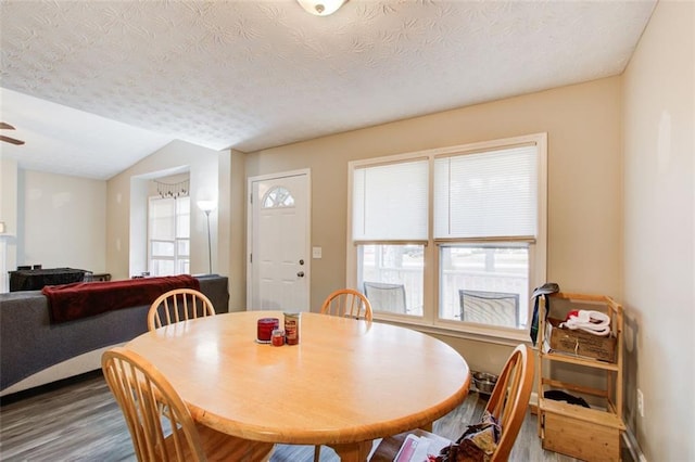 dining room with a textured ceiling, a ceiling fan, lofted ceiling, and wood finished floors