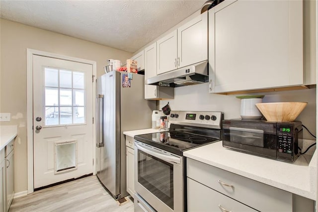 kitchen with light wood-style flooring, under cabinet range hood, a textured ceiling, stainless steel appliances, and light countertops