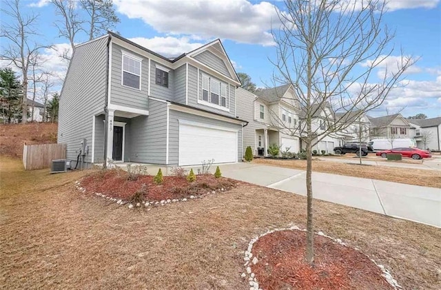 view of front of house featuring driveway, central AC, an attached garage, and a residential view