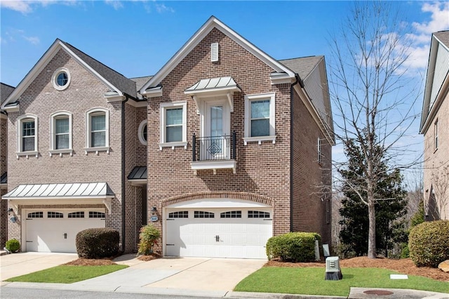 view of front of property with driveway, a standing seam roof, an attached garage, and brick siding