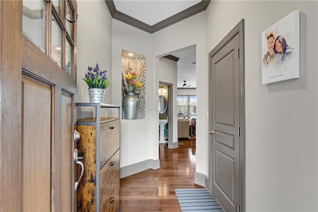 hall with crown molding, baseboards, and wood finished floors