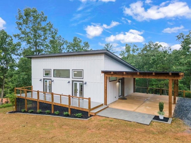 back of house featuring a wooden deck, a yard, and french doors