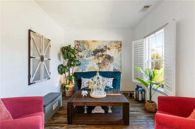 living area with visible vents and wood finished floors