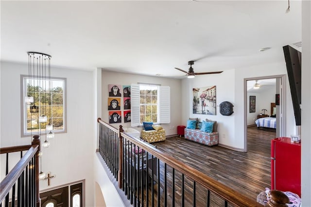 hallway featuring an upstairs landing, plenty of natural light, baseboards, and wood finished floors