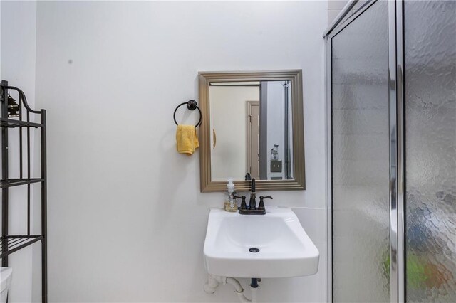 full bathroom featuring a shower stall and a sink