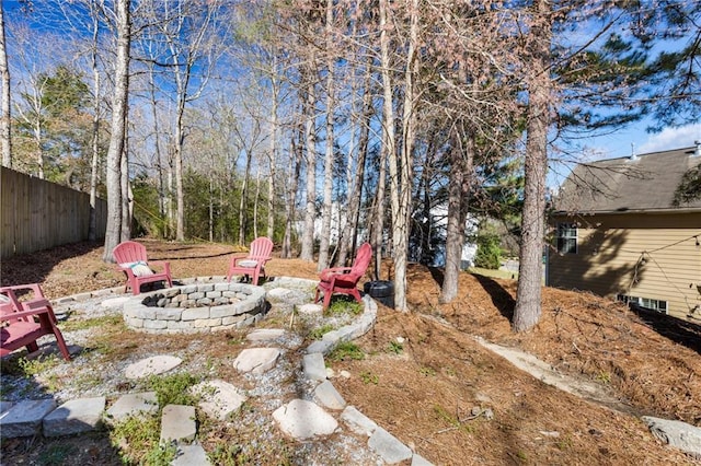 view of yard with fence and an outdoor fire pit