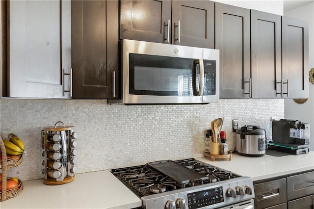 kitchen featuring light countertops, dark brown cabinets, backsplash, and stainless steel appliances