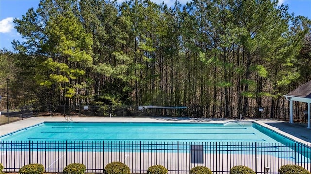 community pool with a patio area and fence
