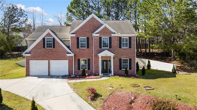colonial home featuring brick siding, driveway, and a front yard