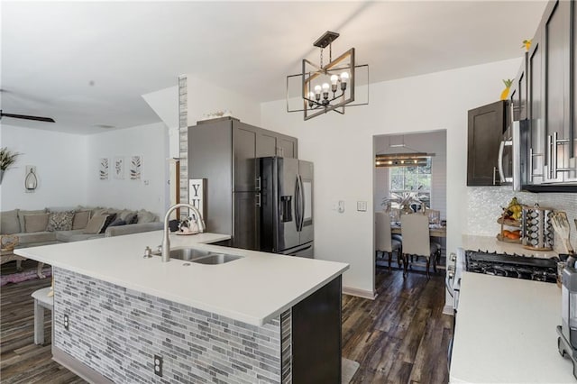 kitchen featuring a notable chandelier, dark wood-style floors, appliances with stainless steel finishes, and a sink