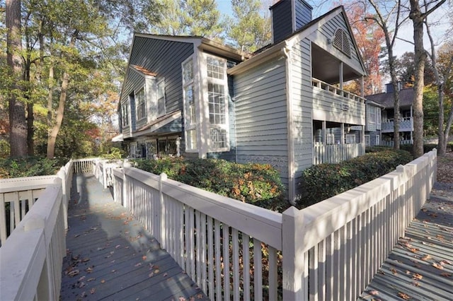 view of side of home with a chimney and a balcony