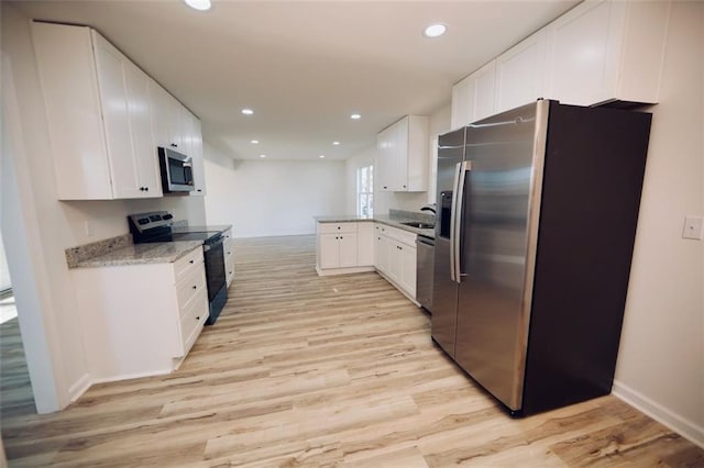 kitchen featuring light stone counters, sink, white cabinets, and stainless steel appliances