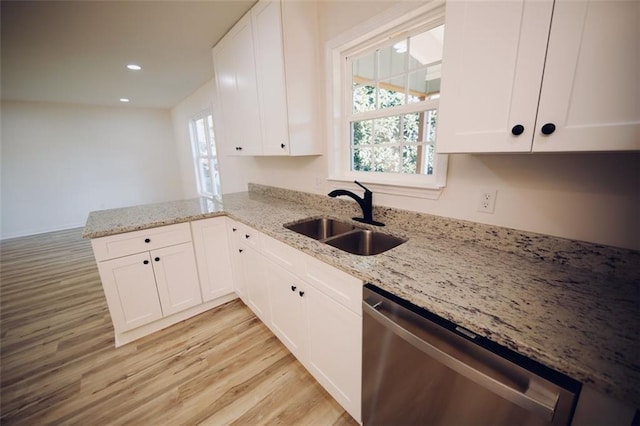 kitchen featuring light stone countertops, dishwasher, sink, kitchen peninsula, and white cabinets