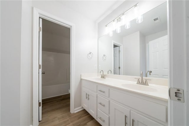 4495 Riders Ridge Trl, Snellville, GA 30039 - full bathroom featuring double vanity, wood finished floors, baseboards, toilet, and a bathtub