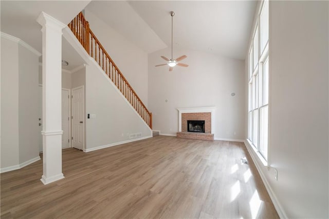 4495 Riders Ridge Trl, Snellville, GA 30039 - unfurnished living room featuring a ceiling fan, stairway, light wood-style floors, a fireplace, and high vaulted ceiling
