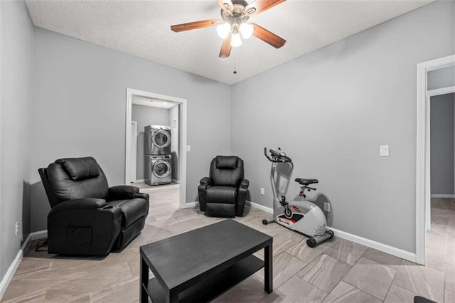 650 Ira St SW, Atlanta, GA 30312 - exercise area featuring a textured ceiling, stacked washer / drying machine, baseboards, and ceiling fan