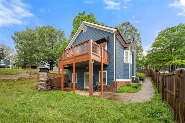 650 Ira St SW, Atlanta, GA 30312 - rear view of property featuring brick siding, a fenced backyard, a wooden deck, central AC unit, and a lawn