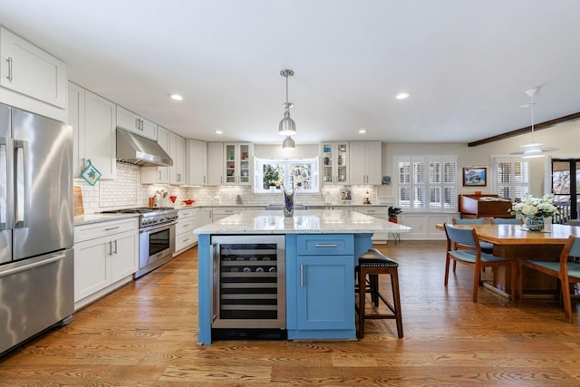 kitchen featuring under cabinet range hood, beverage cooler, stainless steel appliances, white cabinetry, and glass insert cabinets