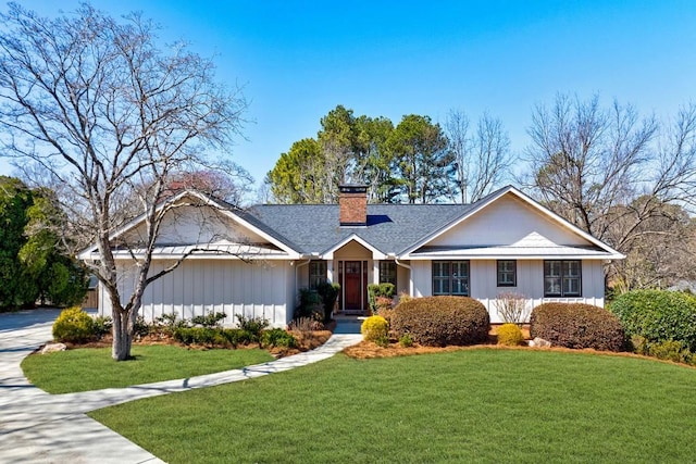 ranch-style home with driveway, a front lawn, and a chimney