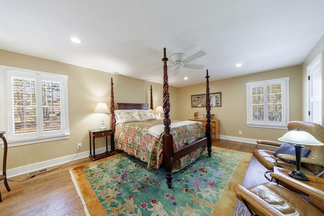 bedroom with multiple windows, visible vents, and wood finished floors