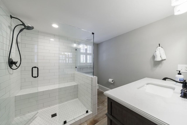 bathroom with a stall shower, a sink, and baseboards