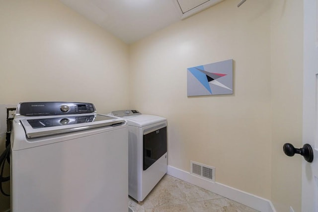 laundry area with light tile patterned floors, visible vents, washer and dryer, laundry area, and baseboards