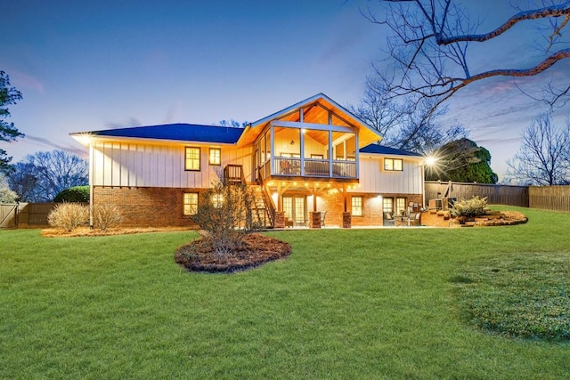 back of house featuring a yard, brick siding, a patio area, and a fenced backyard