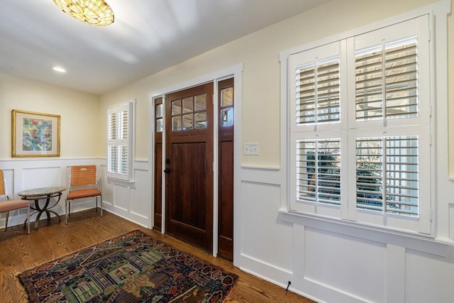 entryway featuring a wainscoted wall, a decorative wall, wood finished floors, and recessed lighting