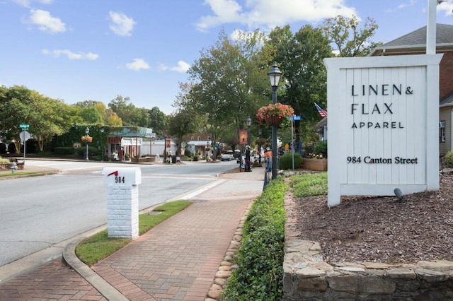 view of street with traffic signs, curbs, sidewalks, and street lights