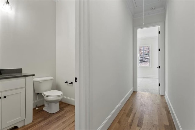 bathroom featuring vanity, crown molding, hardwood / wood-style floors, and toilet