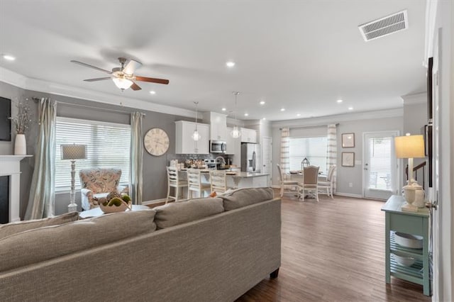 living room featuring crown molding, dark wood-type flooring, and ceiling fan