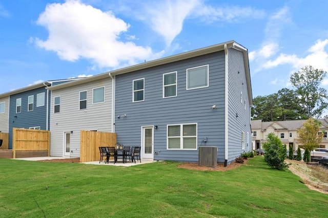 back of house featuring central AC, a patio area, and a lawn